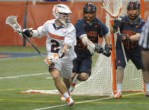 Syracuse attack Kevin Rice breaks away from Virginia defenders in the Orange's 9-8 win over the Cavaliers on Friday in the Carrier Dome. Rice's goal in overtime sent Syracuse to its second win of the season.