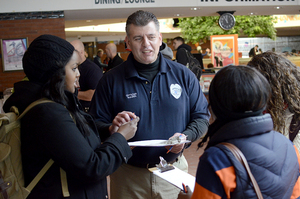 George Wazen, a public safety officer, talks with students at the “Wrap with DPS” event in the Schine Atrium. The goal of the event was to build relationships between students and DPS officers.