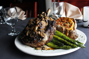 The 40-ounce ribeye is topped with mushrooms and comes with a side of cheesy baked potato. 