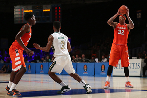 Dajuan Coleman holds the ball above his head near the top of the key. He chipped in seven rebounds, three assists and three blocks in 21 minutes played.