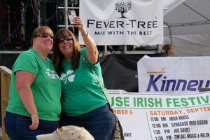 Two green-clad festival goers pose for a selfie in front of the Clonakilty Stage.