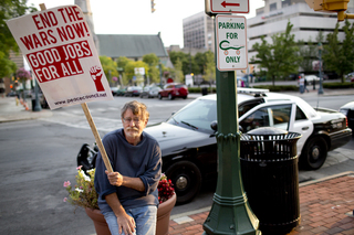 Ed Kinane, an Occupy supporter and resident of Syracuse for 68 years, rests outside City Hall during the protest.