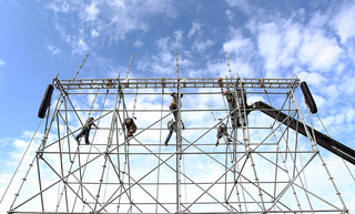 Workers are seen assembling scaffolding to hold video screens aboard the USS Midway Museum on Nov. 8, 2012, before the Battle on the Midway game between the Syracuse Orange and the San Diego State Aztecs scheduled for Sunday.