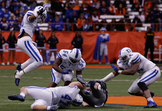 Kimble is brought down, while a handful of Duke defenders look on. 