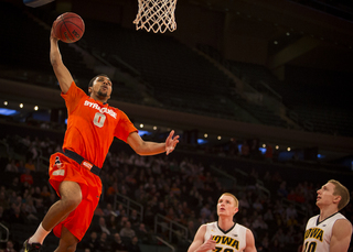 Gbinije rises for a layup as two Hawkeye defenders watch the forward soar toward the rim.