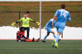 Hilpert holds his arms wide and yells after the Tar Heels scored. Miller sits on the ground.