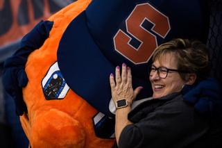 Otto the Orange hugs a fan.